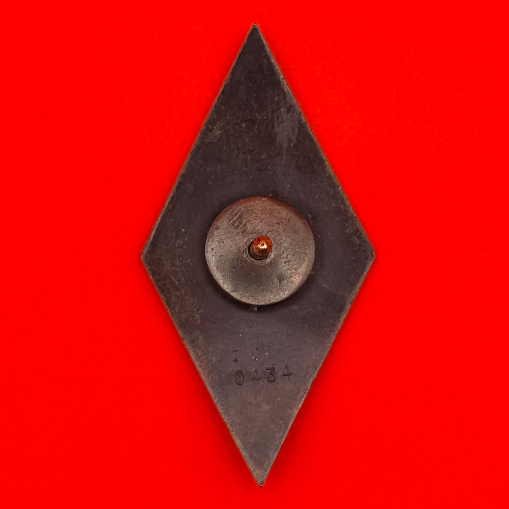 Reverse side of diamond-shaped Mongolian award badge showing screw-back attachment and North Korean Pyongyang Mint