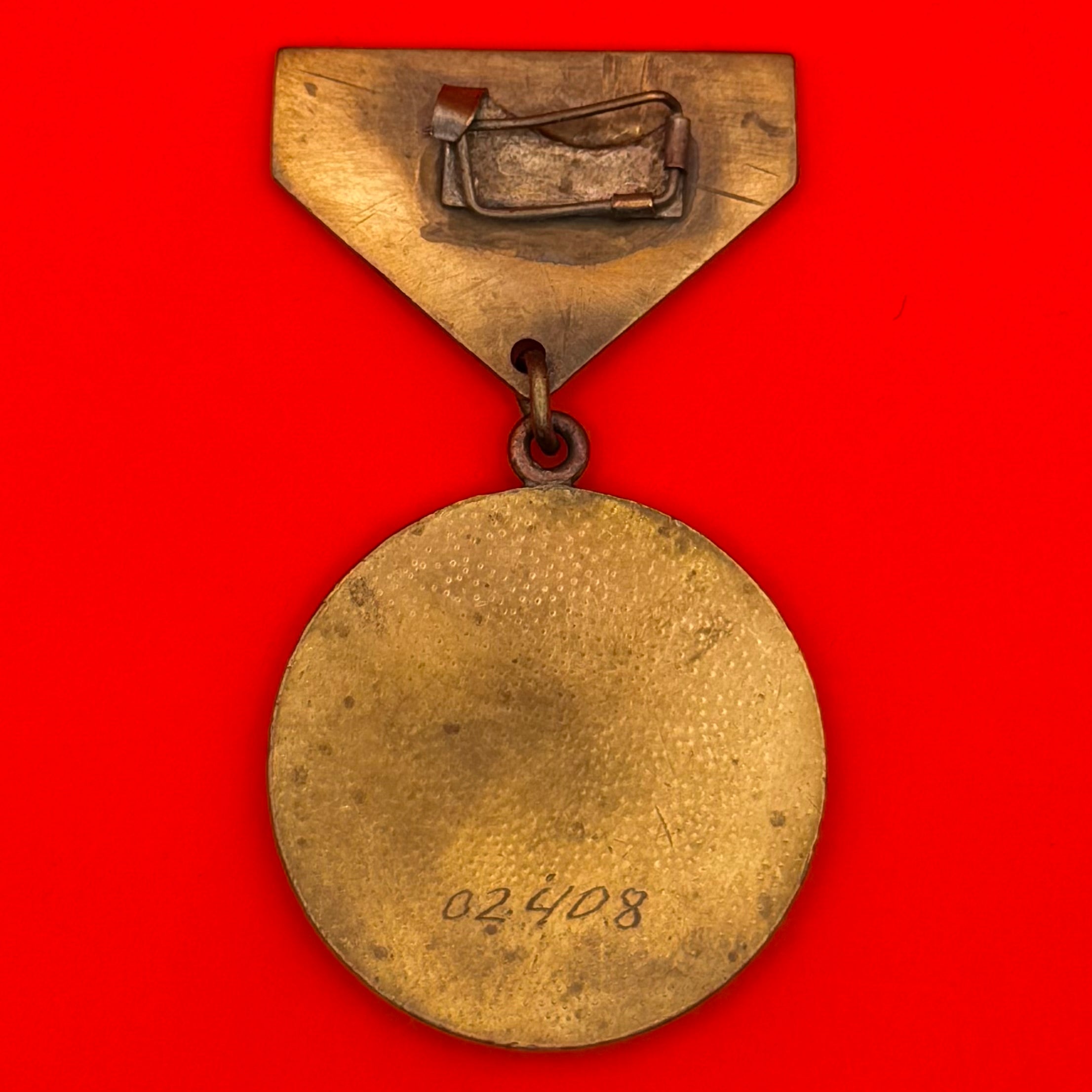 Reverse side of Cold War-era Mongolian labor medal showing engraved serial number
