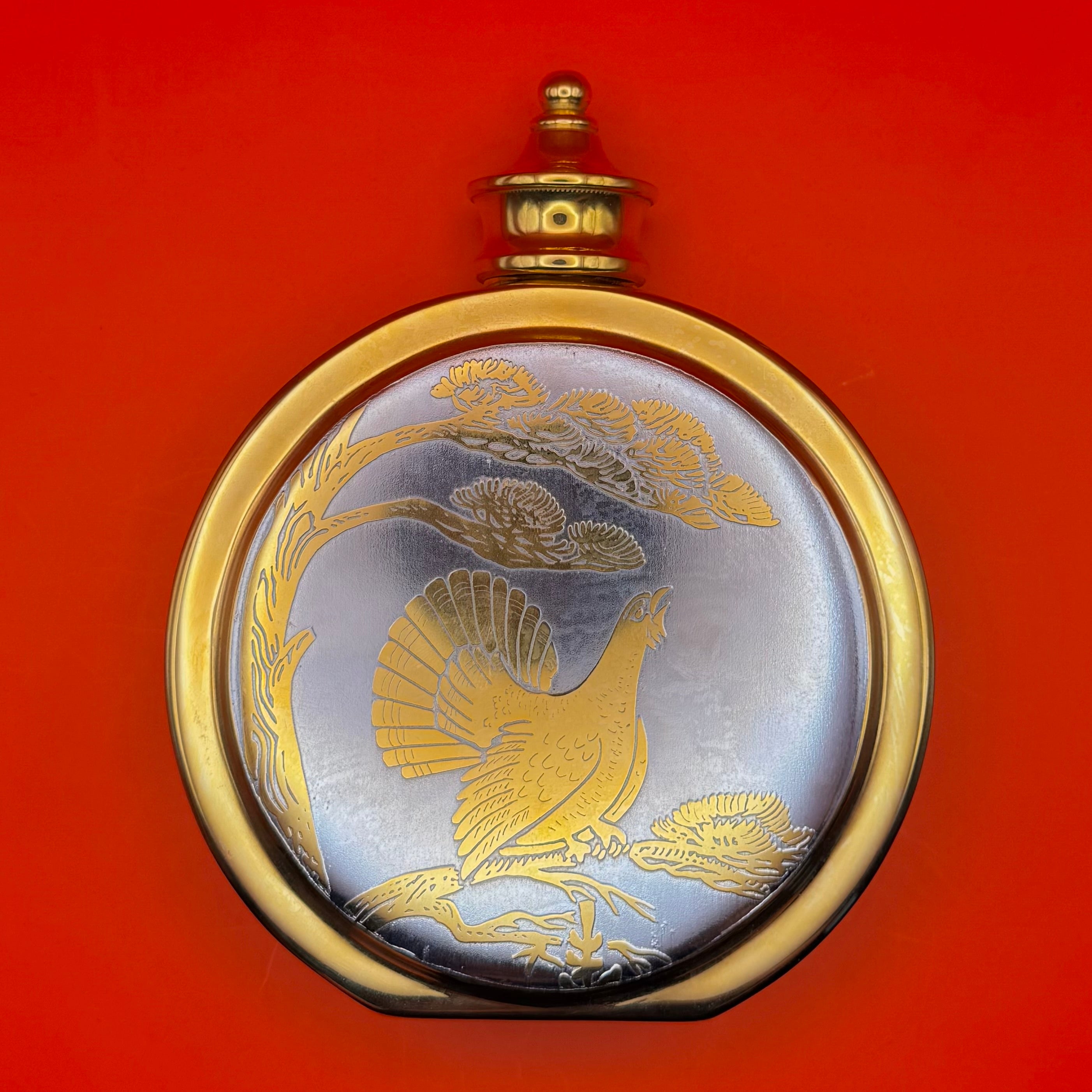Russian luxury hunting flask with gold wildlife engraving featuring capercaillie bird in forest scene