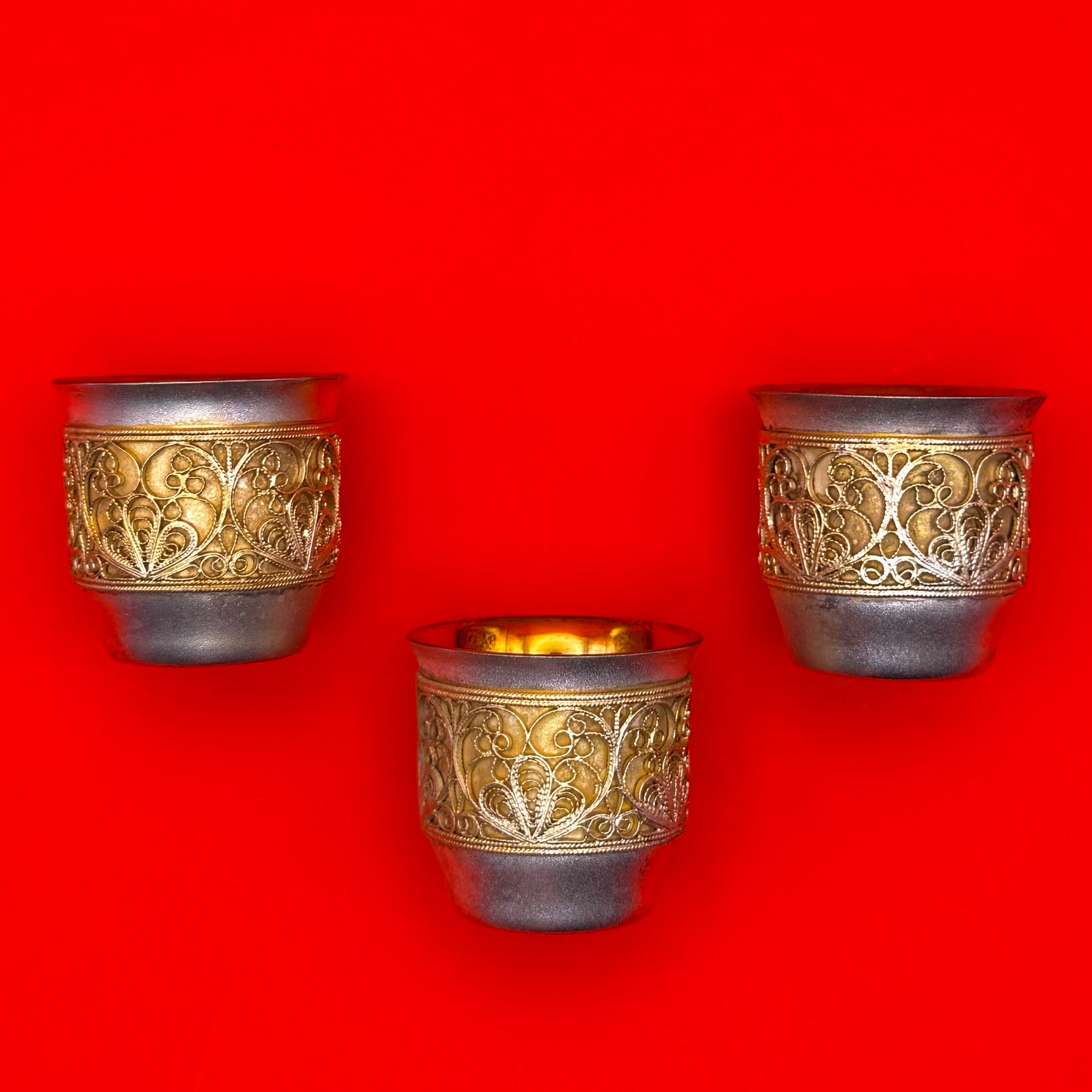 Set of three Russian gold-plated brass shot cups with filigree design included in premium gift set