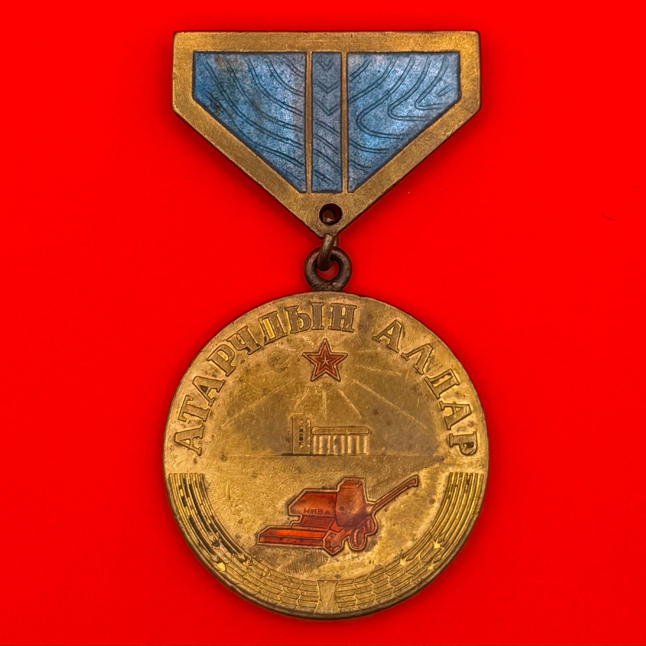 Front view of 1980s Mongolian Virgin Land Cultivators Medal with enamel ribbon and Niva harvester design