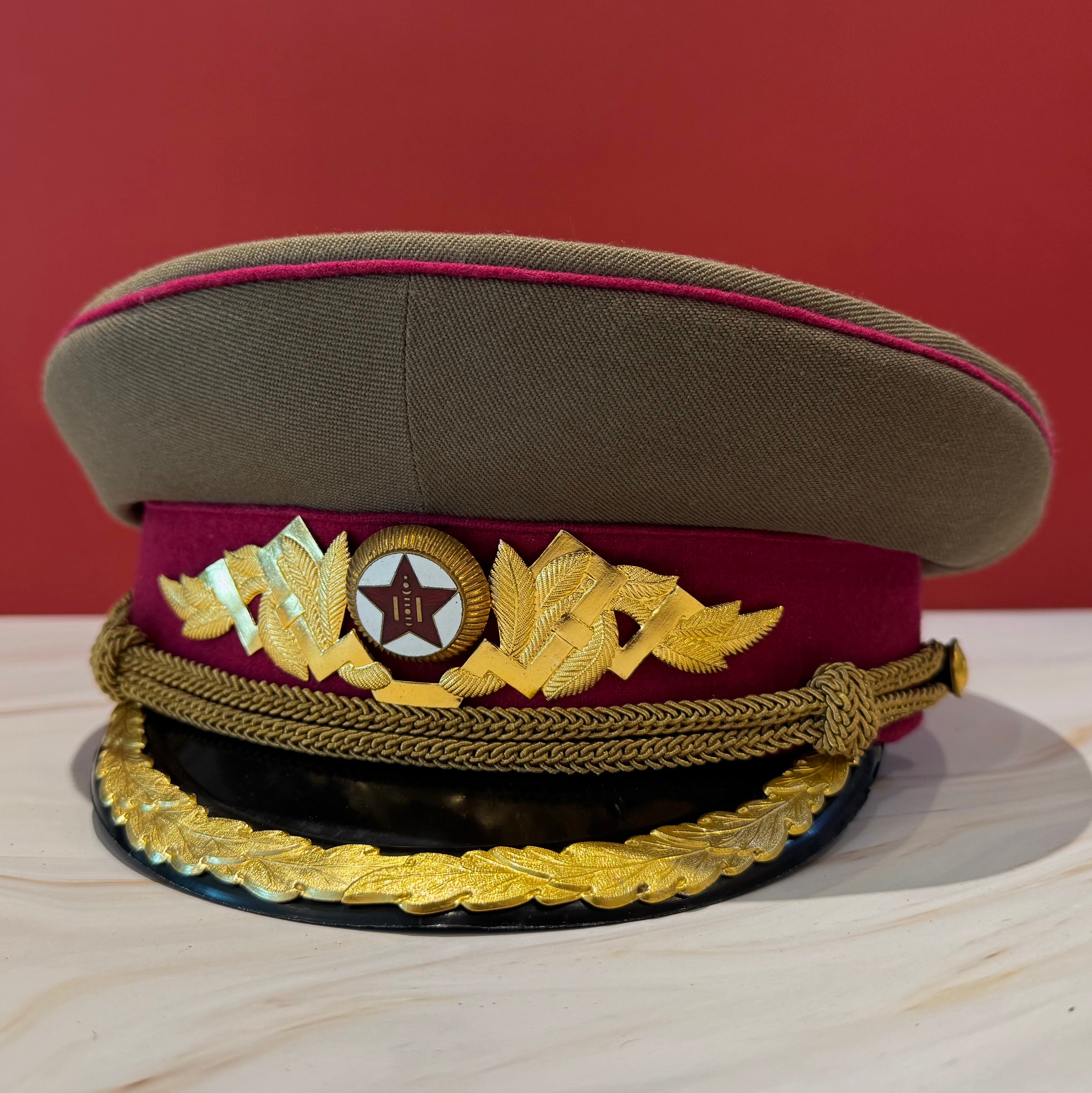 1960s Mongolian KGB spy officer visor cap with dark olive crown, crimson band, and firm black visor. A rare piece of Cold War-era intelligence memorabilia for collectors of espionage artifacts from behind the Iron Curtain.