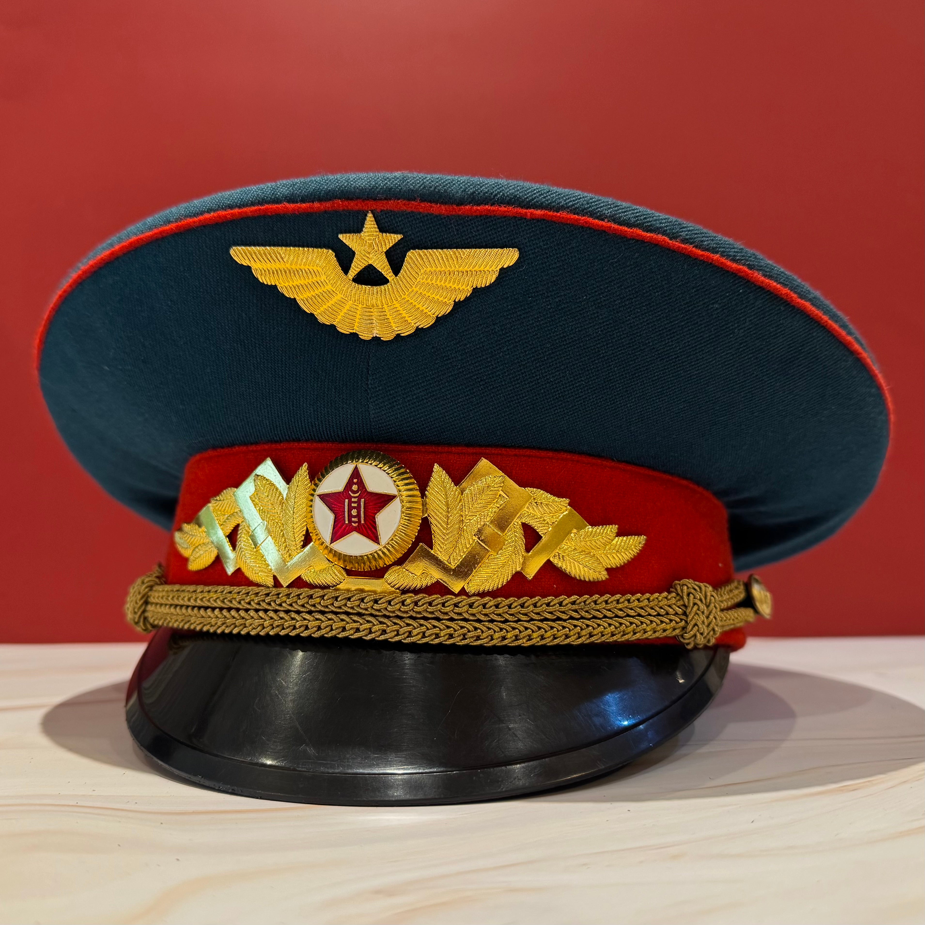 1980s Mongolian Air Force officer parade visor cap with Soviet-style winged star emblem and oak leaf insignia