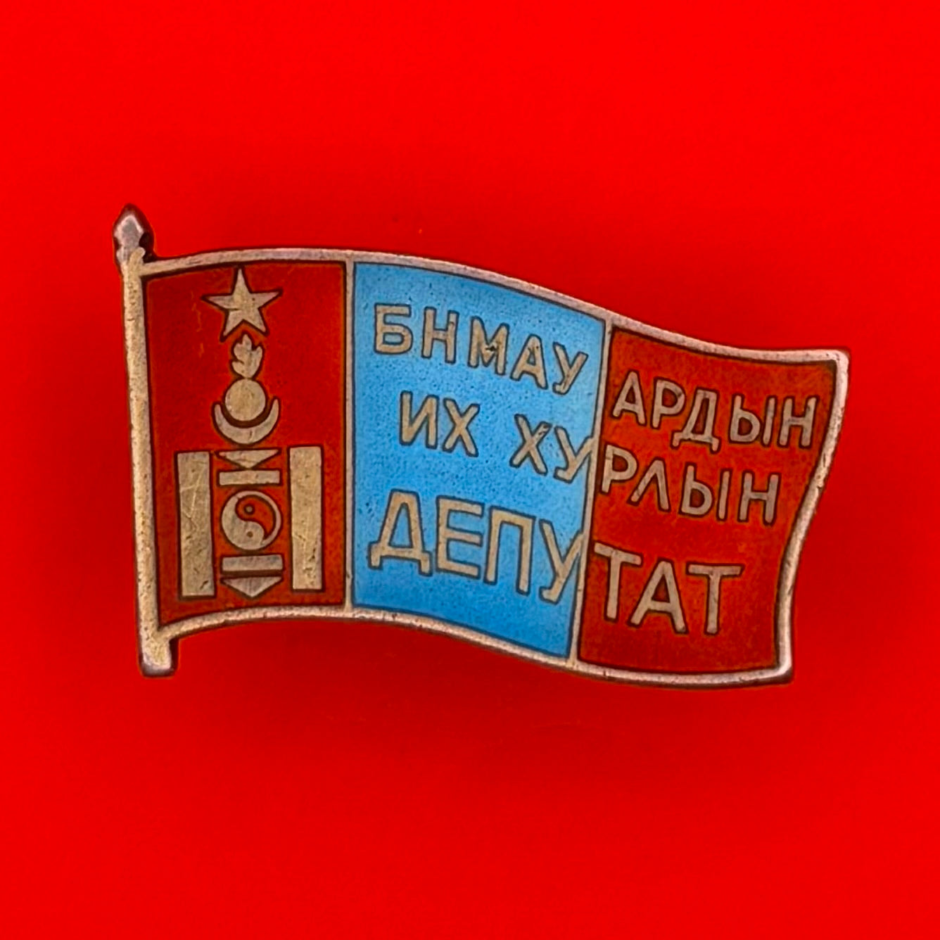 Front view of 1960s Mongolian Great Khural Deputy Badge with socialist-era red and blue enamel design