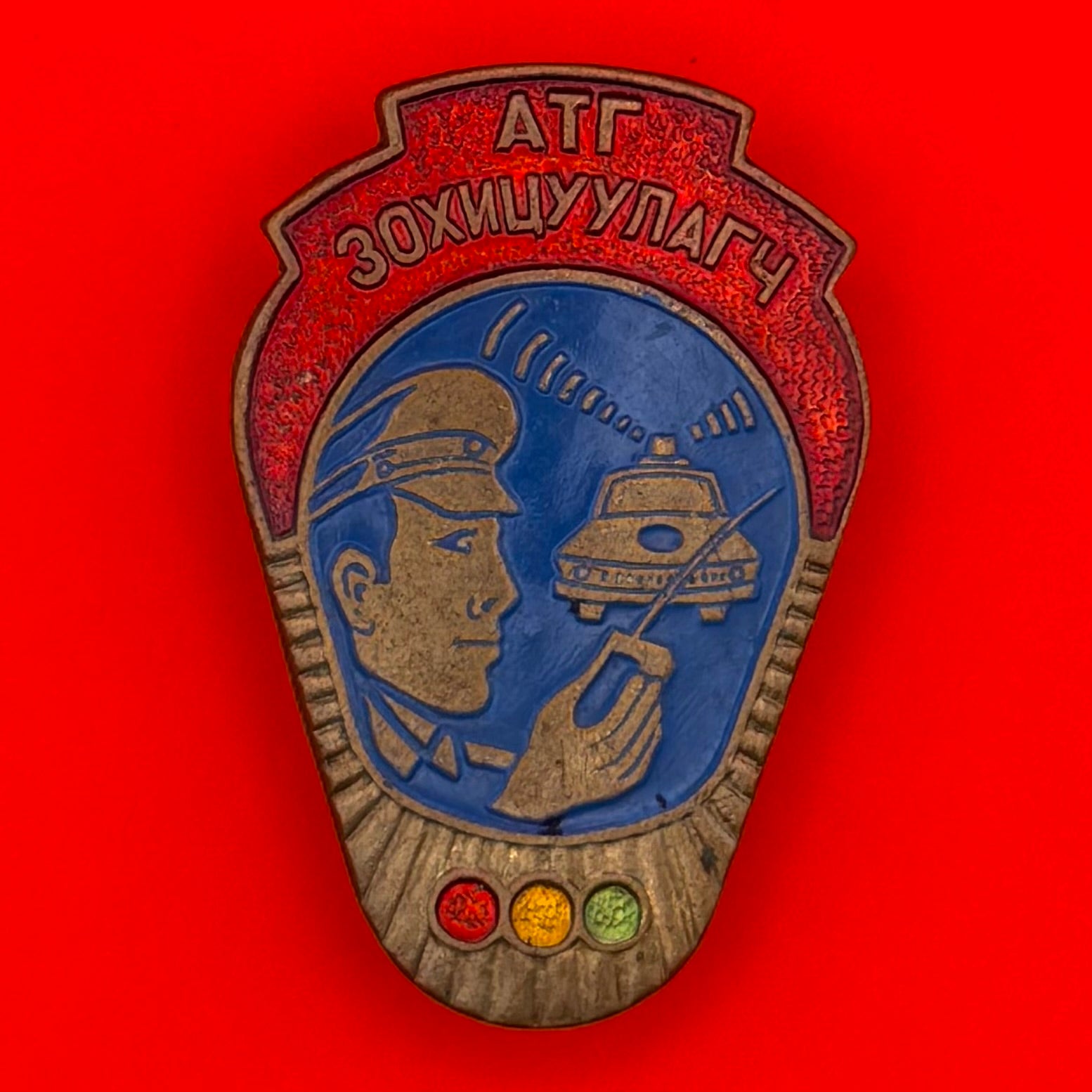Front view of 1970s Mongolian Traffic Controller badge showing officer with radio and patrol car imagery