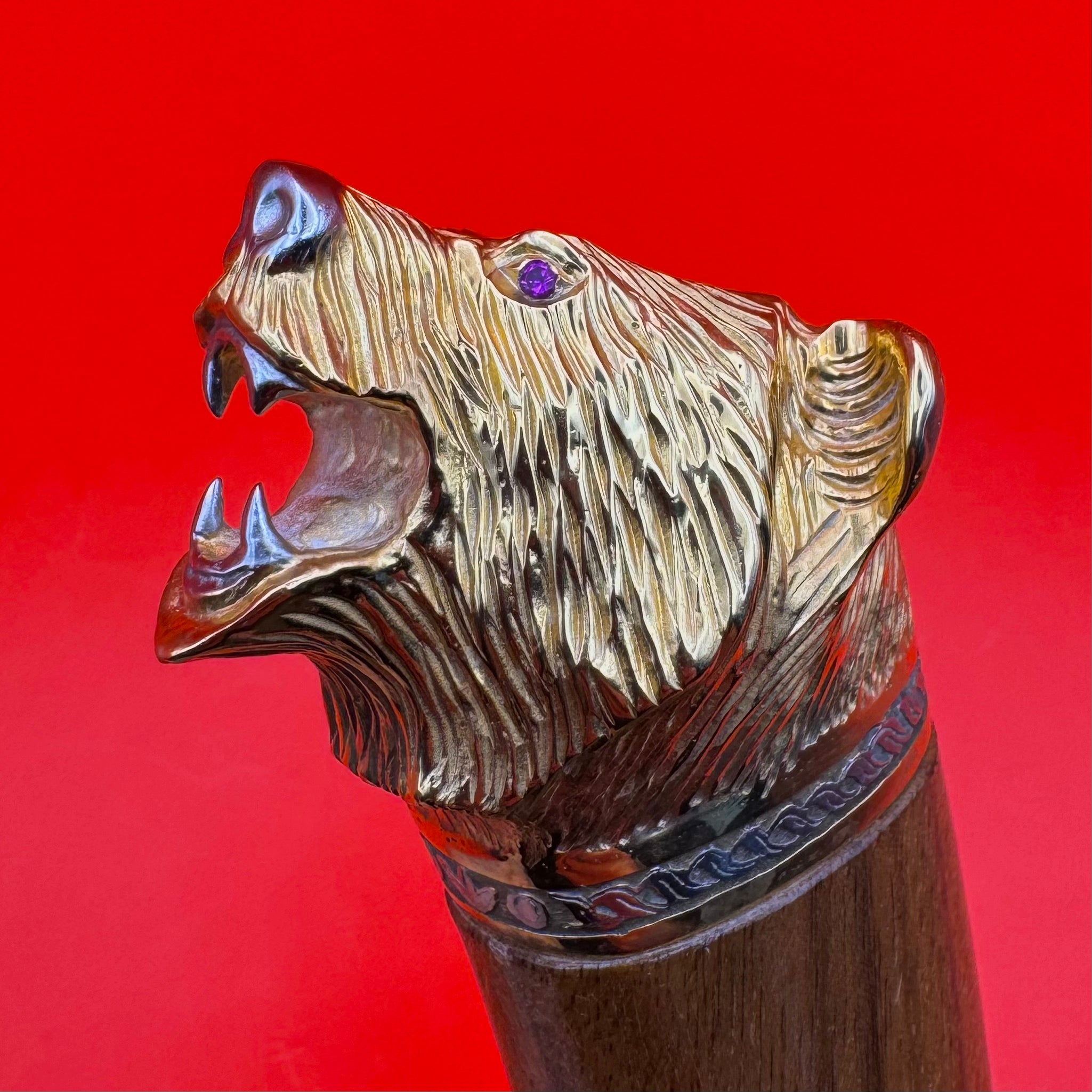 Close-up of sculpted bear head pommel with gemstone eye on luxury Russian knife handle