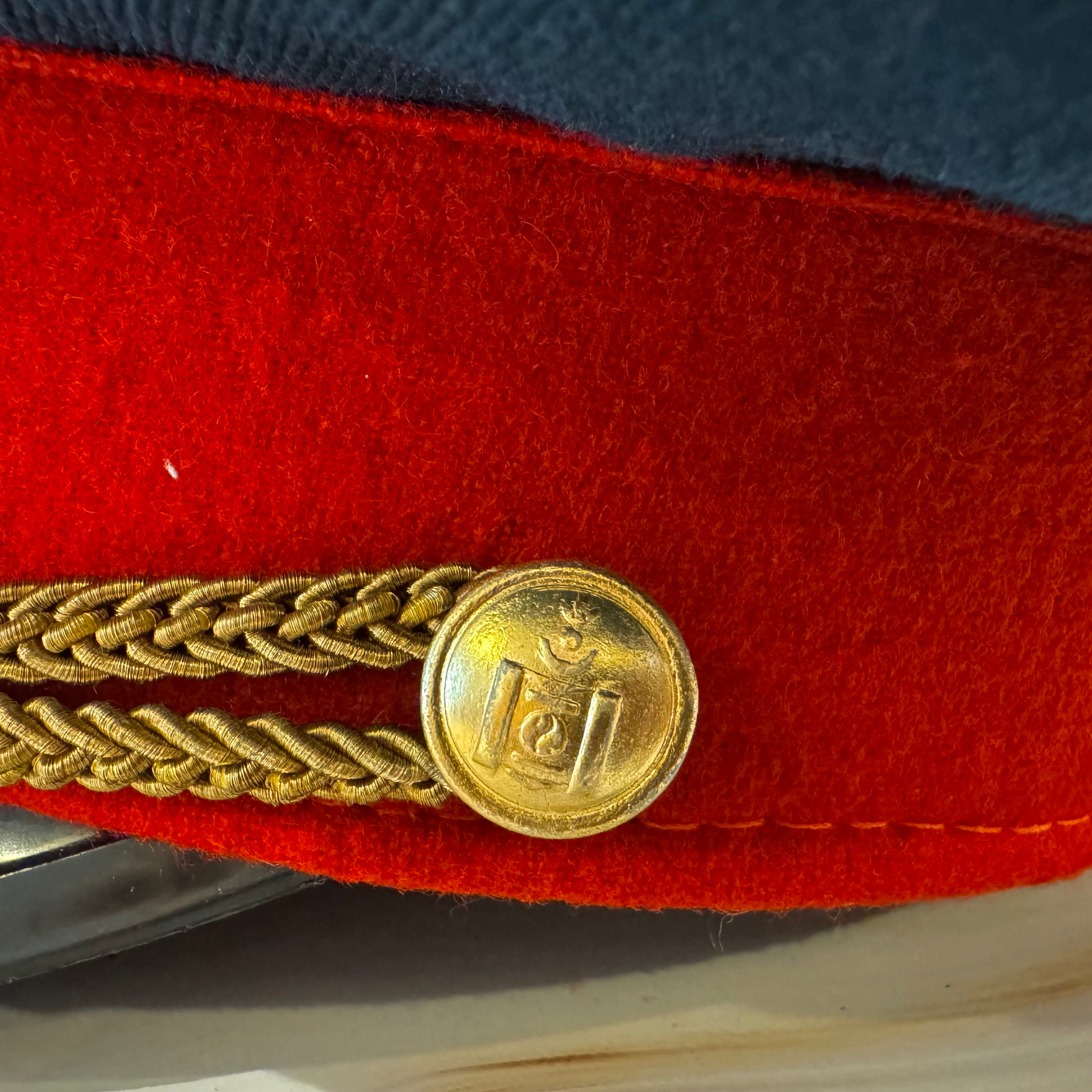 Detailed view of Mongolian Air Force officer cap side button and wool fabric from communist-era military dress