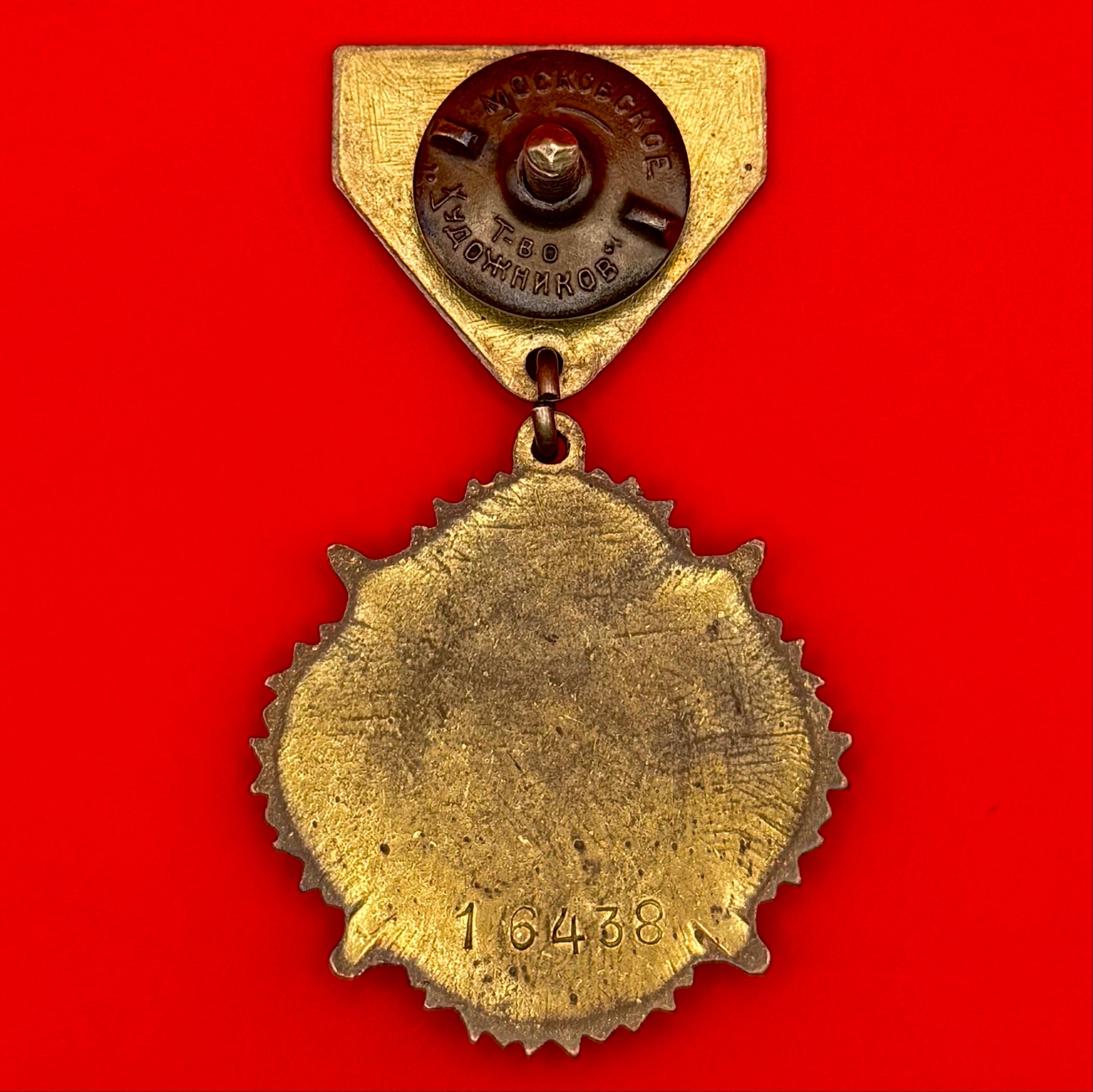Reverse side of WWII-era Mongolian victory medal showing engraved serial number and screw-back plate