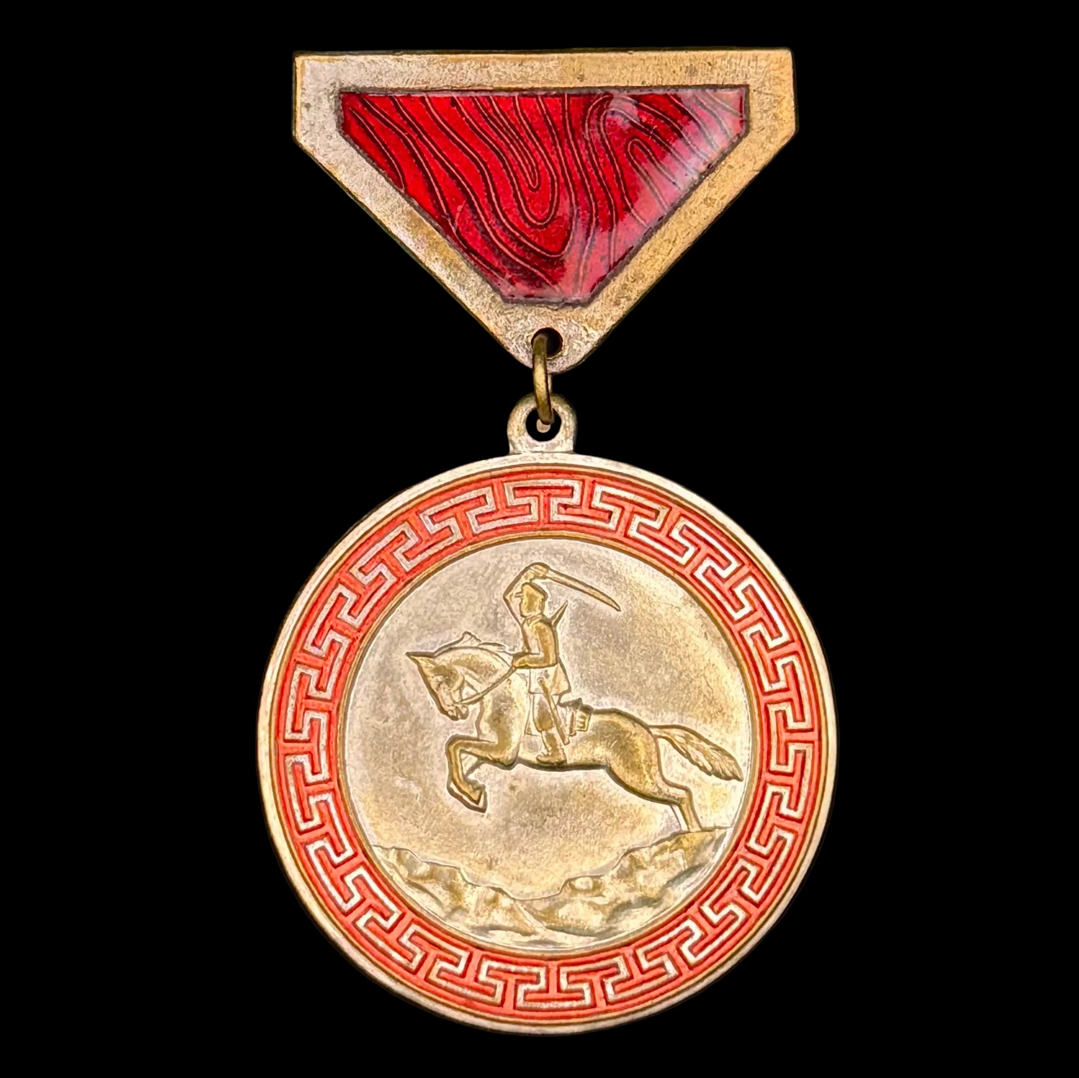 Medal with a red and gold design on a black background