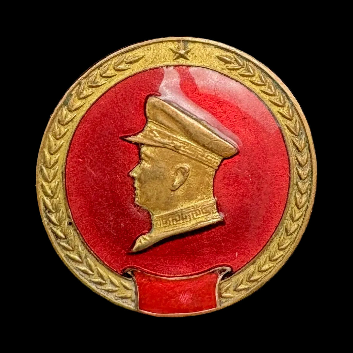 Medal with a profile of a person in a hat on a red background